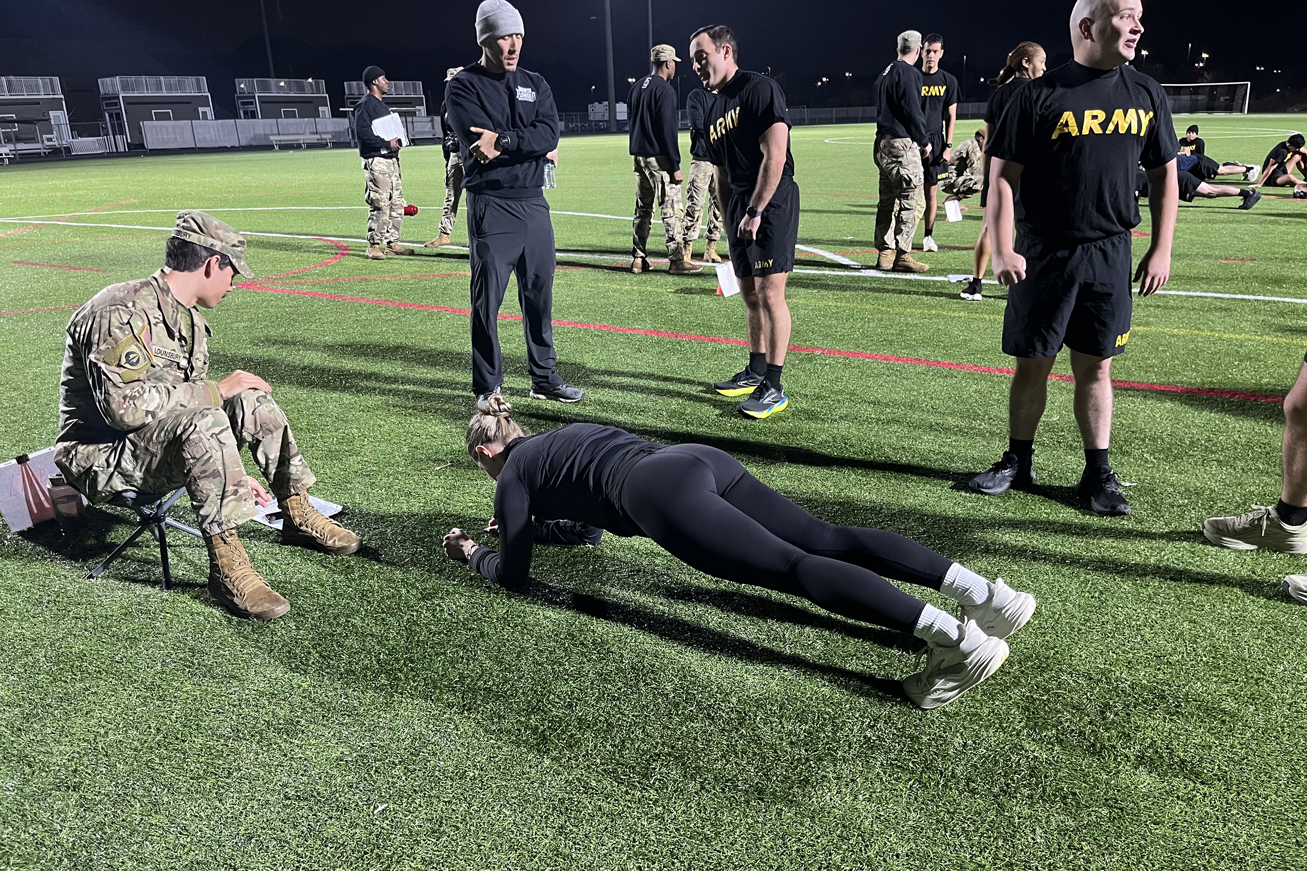 a group of army members on an athletic field running fitness tests